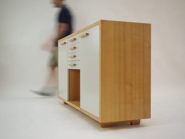 Modern light-wood cabinet with white drawer fronts in a studio setting