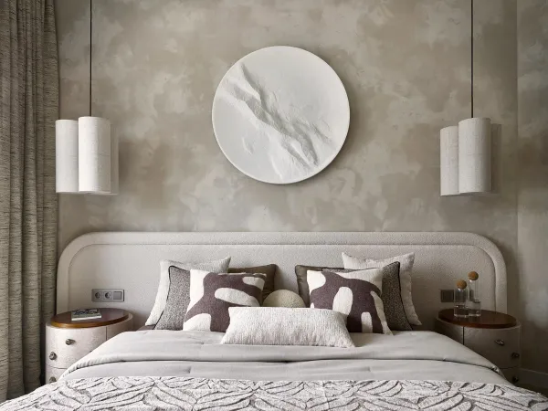 Soft lighting and layered bedside lamps in a minimalist bedroom